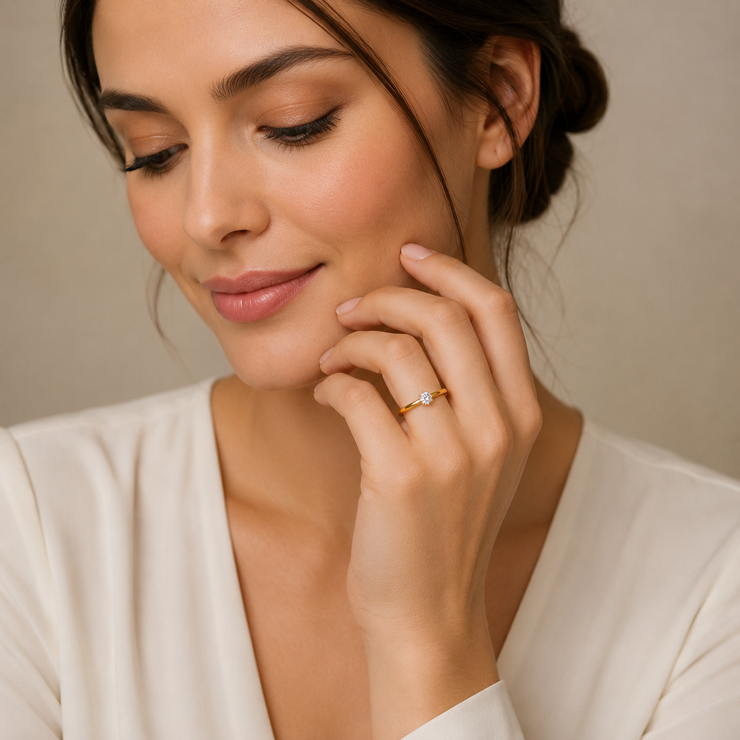 Woman wearing a gold ring with a diamond on a neutral background